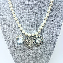 Fashion pearl necklace with three charms ranging from one to one-and-a-half inches.