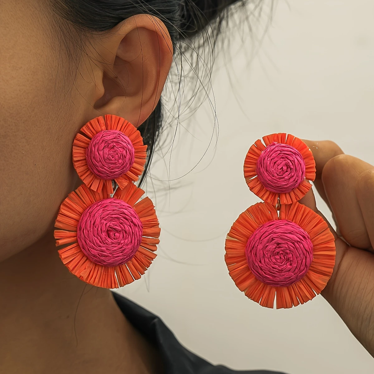 Boho-chic raffia dangle earrings featuring a sunflower motif with a three-inch drop length.