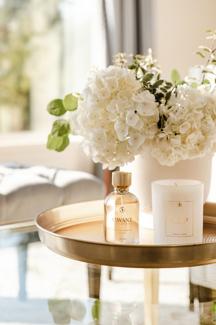 Clear glass bottle with a white pump dispenser containing Fresh Linen room spray.