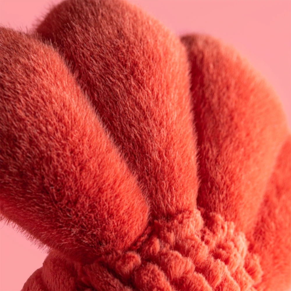 Close-up of the soft, textured red plush fabric on a Jellycat Lobster toy.