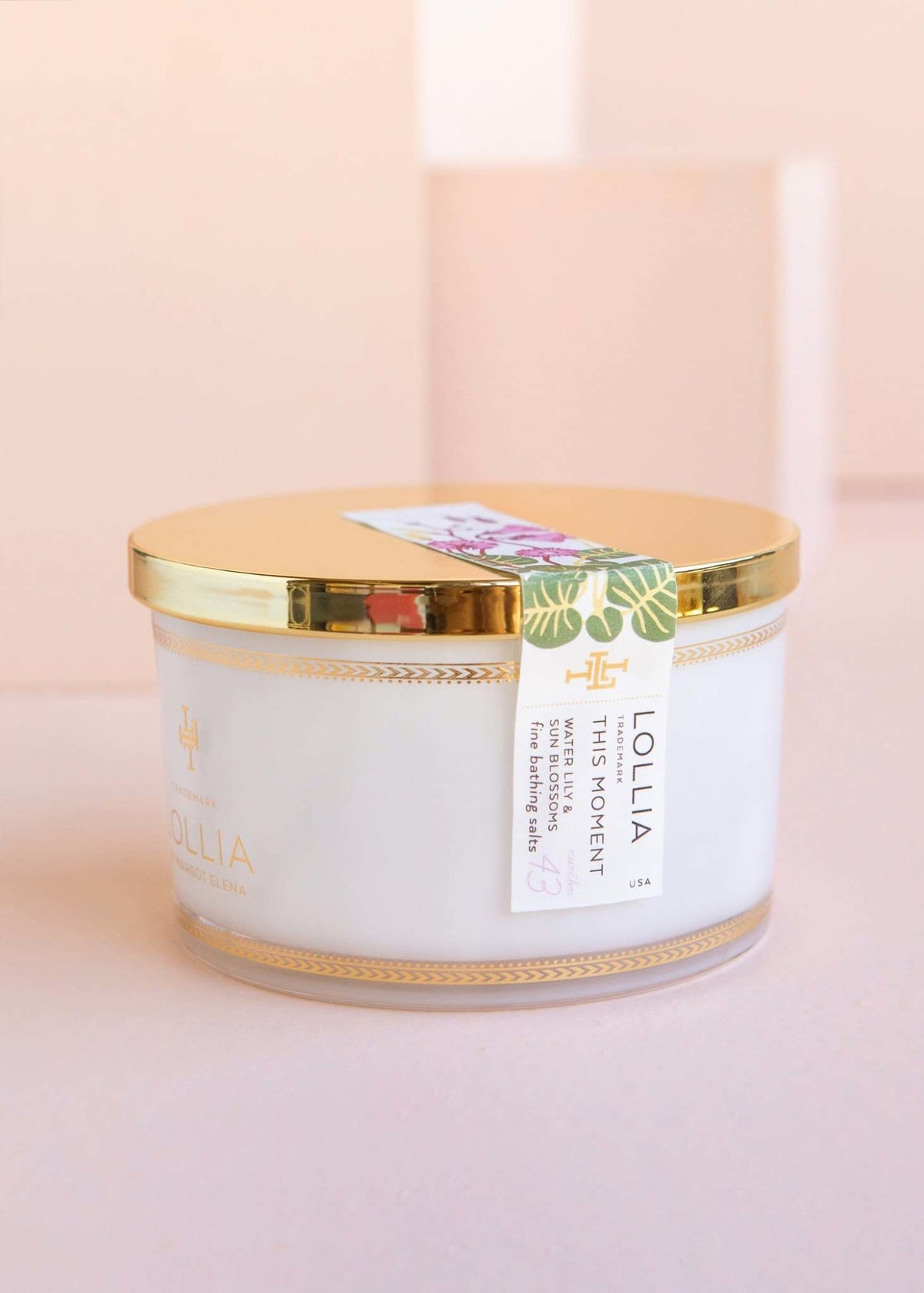 This Moment bath salt jar with a white lid featuring Water Lily, Sun Blossoms, and Honey Amber notes.