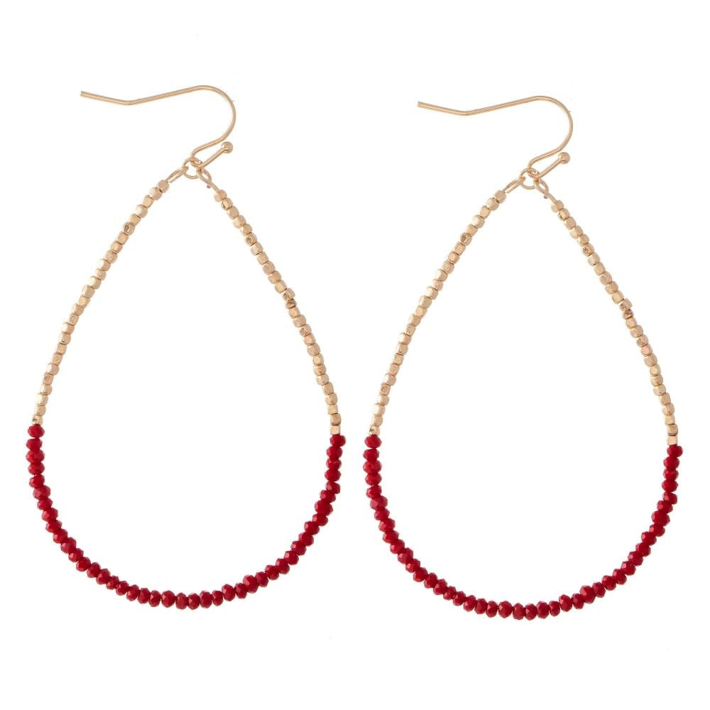 Red beaded teardrop earrings with a long dainty silhouette.