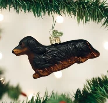 Long-haired Dachshund ornament in brown with black ears on a gold stand.
