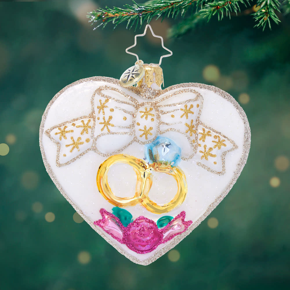 Gold wedding rings featuring an entwined heart gem symbolizing enduring love.