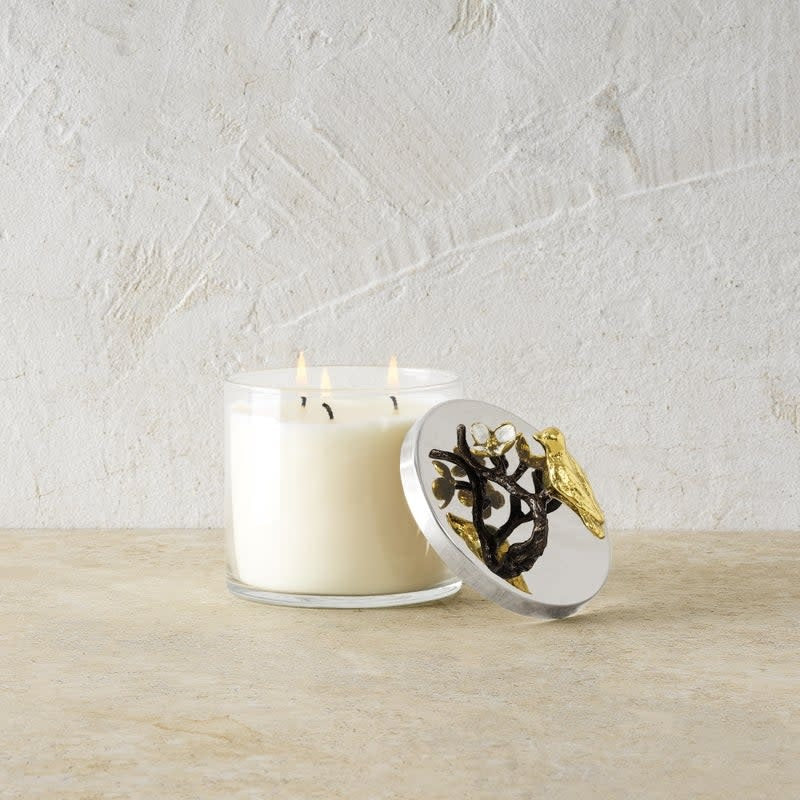 Triple wick soy candle in white enamel glass with natural brass accents; scent includes magnolia and jasmine.