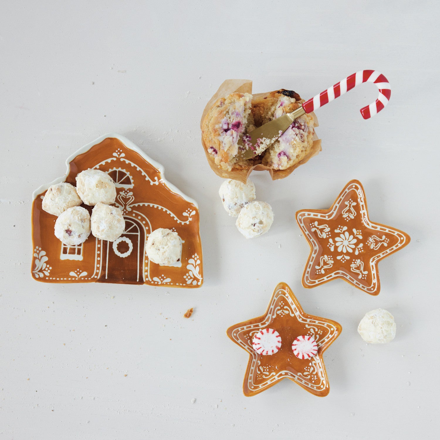 Stainless steel spreader with a red and white striped candy cane resin handle in a muffin.