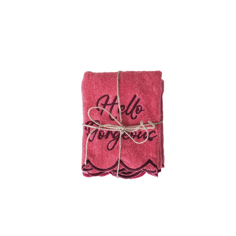 Pink square cotton washcloth with scalloped edges and 'Hello Gorgeous' embroidered in dark thread.