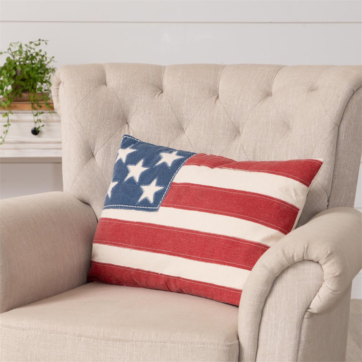 Pillow featuring a patchy American flag pattern with distressed red, white, and blue fabric.