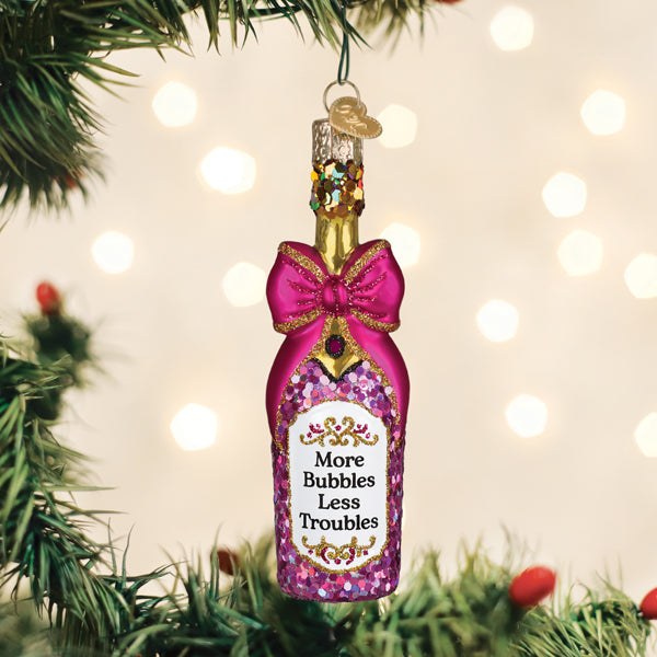 Champagne bottle with a glittering bow ornament tied around the neck.