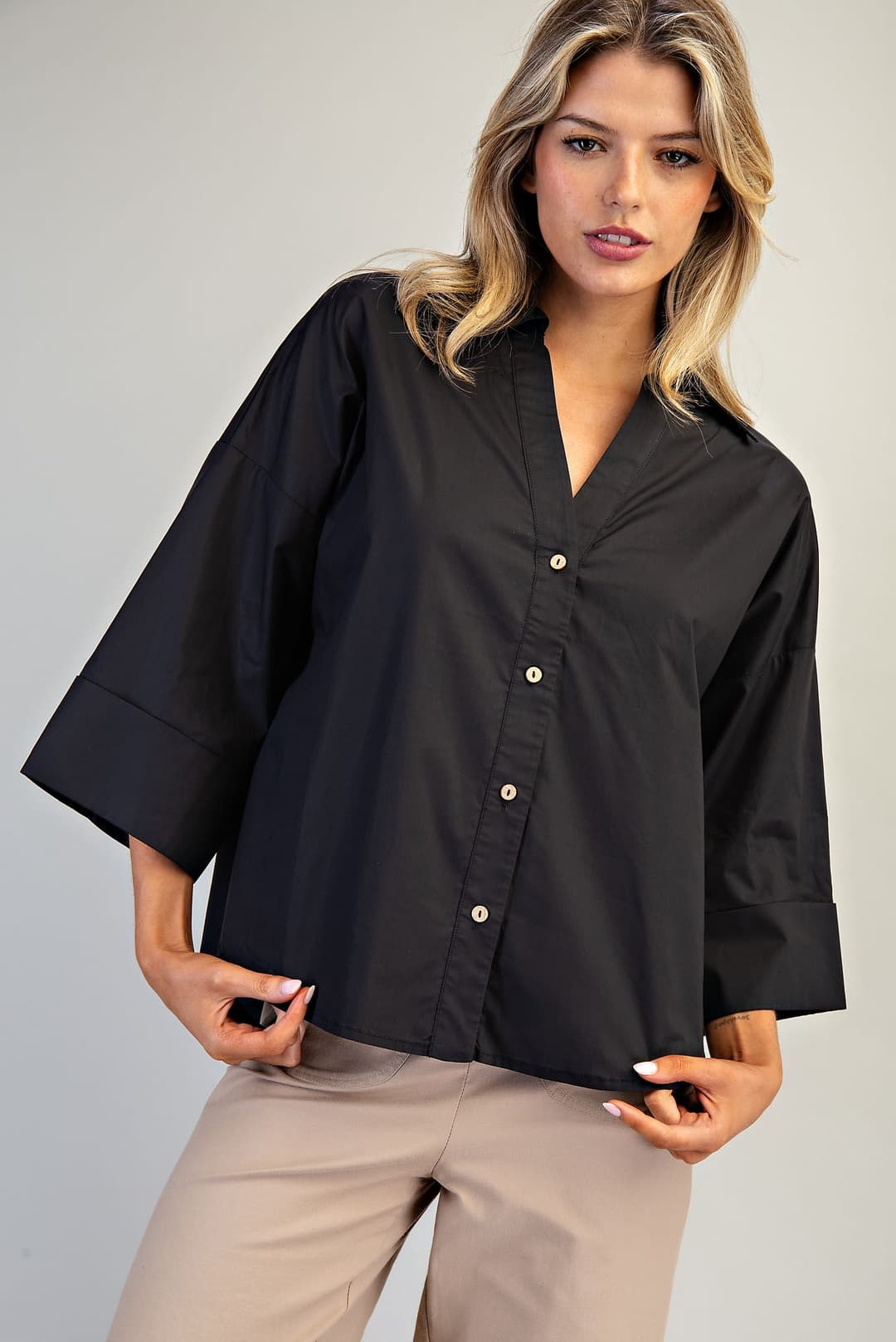 Woman wearing a black Blake Back Pleat Button Down Blouse Top with wide three-quarter sleeves.