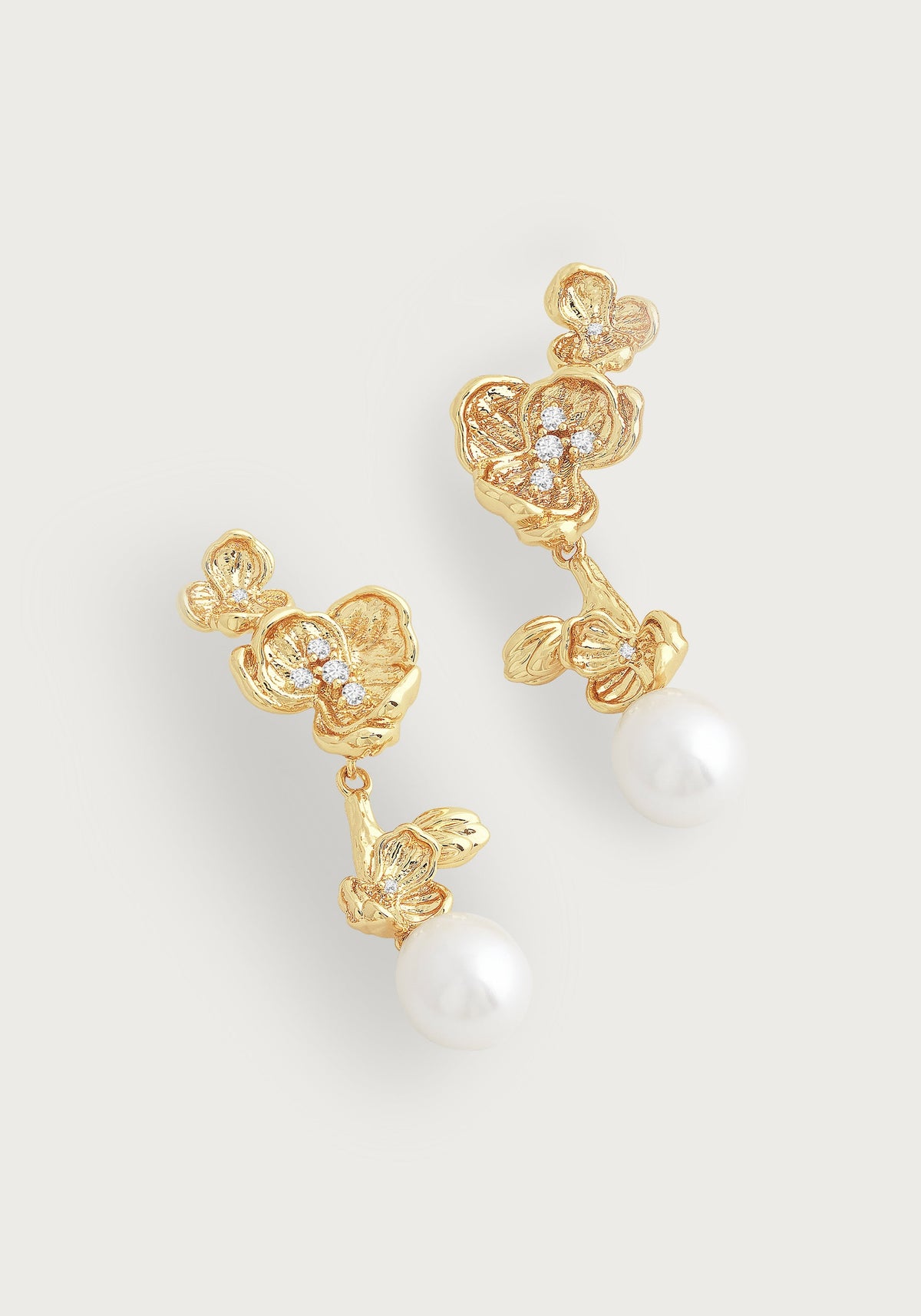 Gold-plated orchid drop earrings with hand-set crystals and white pearl drops on a white background.