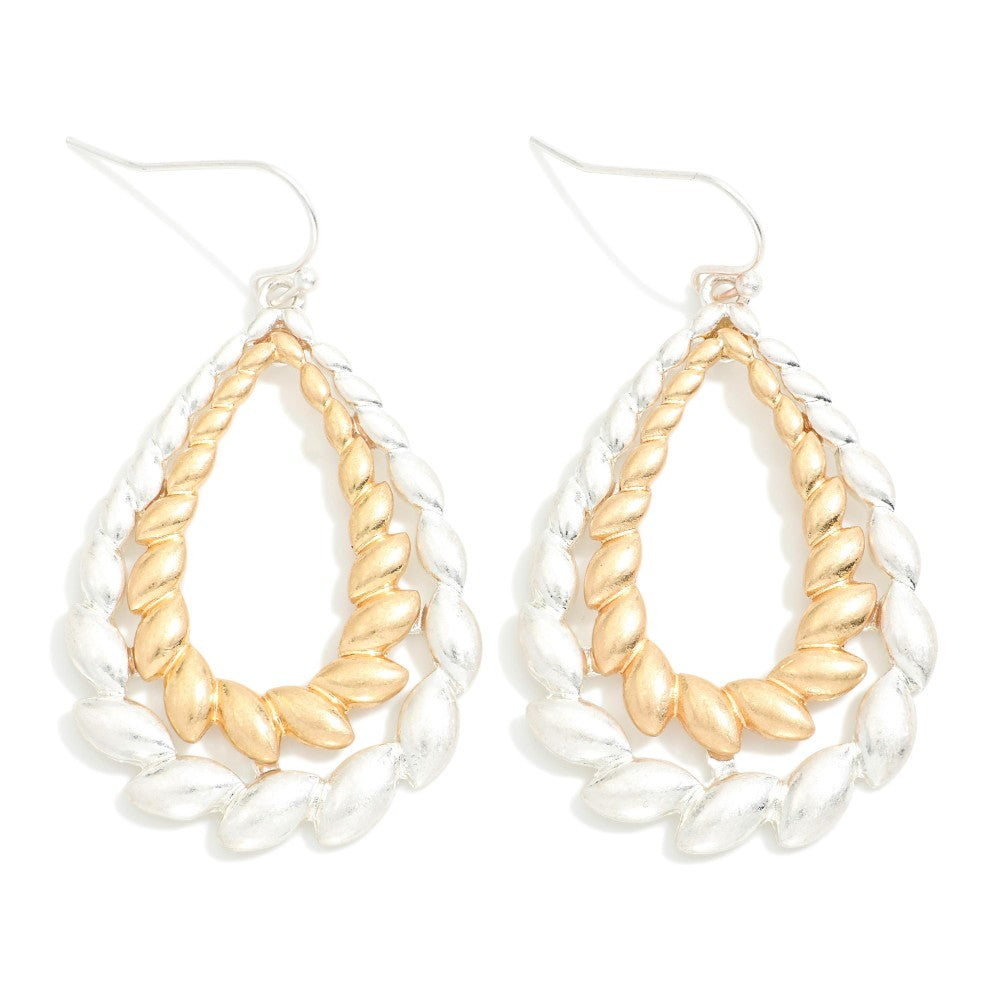 Layered metal seed teardrop drop earrings with multiple textured layers.