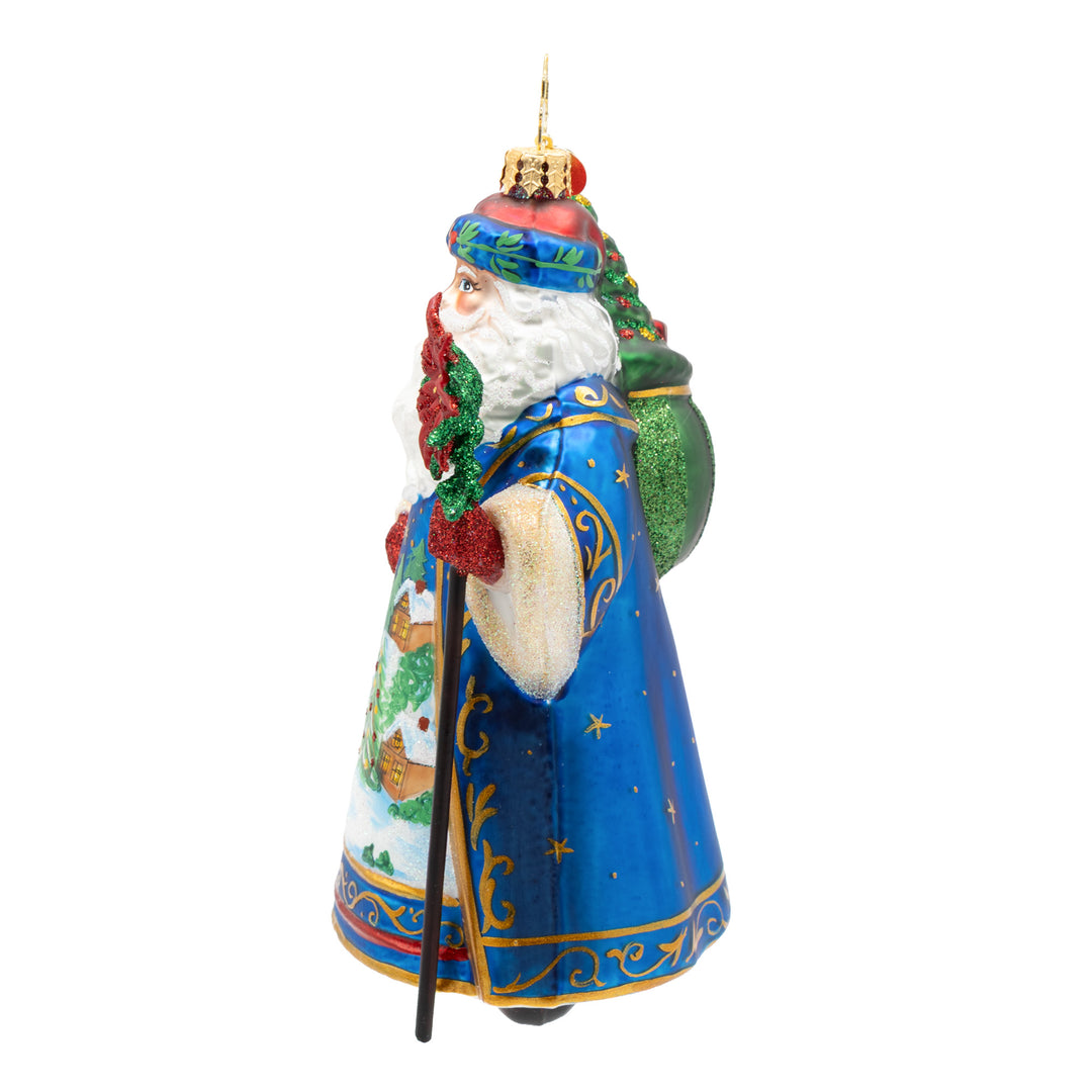 Father Christmas’ Eve glass ornament featuring Santa in a blue robe with a green sack of toys.