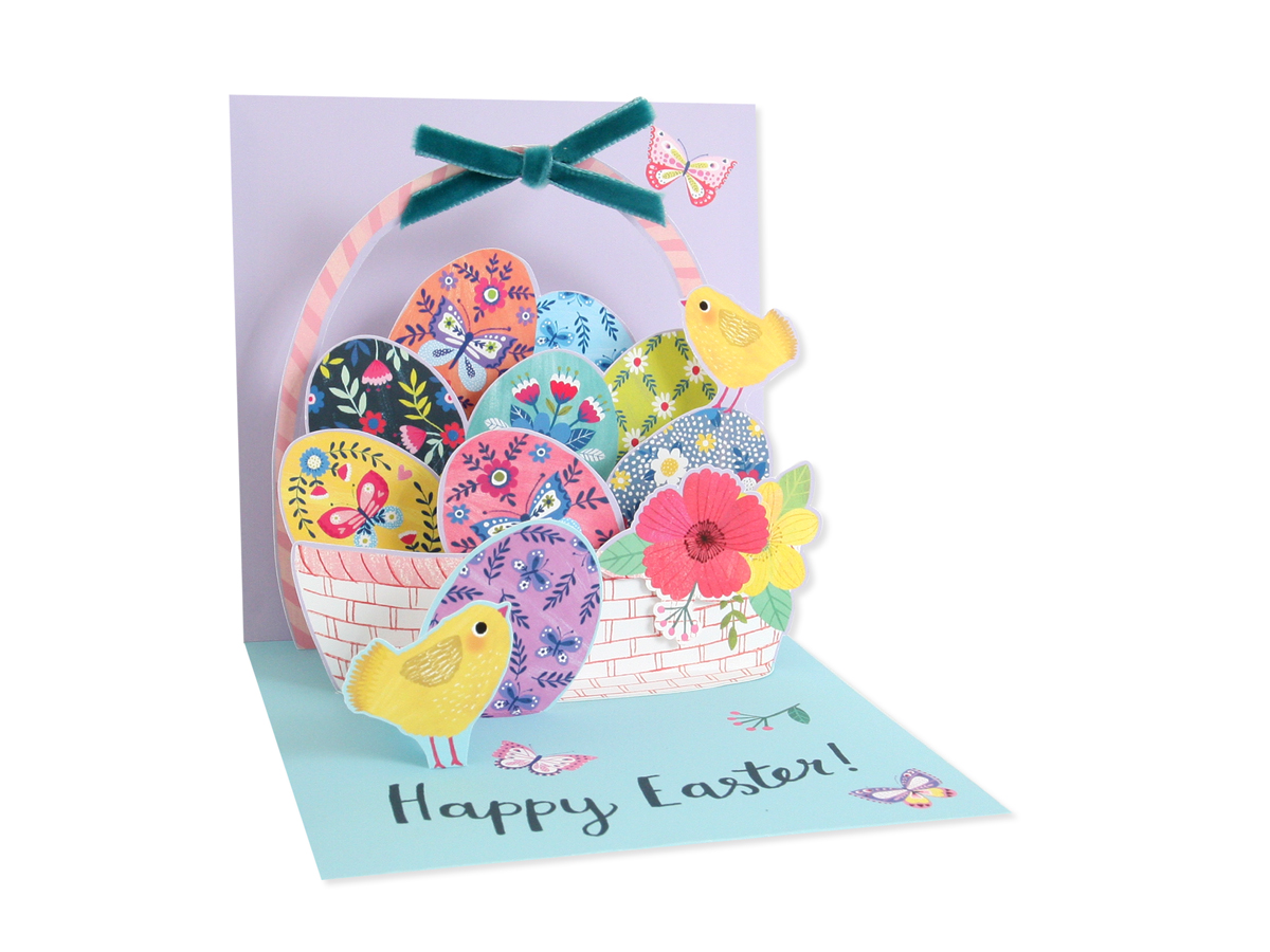 White envelope card with blue bow featuring a basket filled with colorful Easter eggs.