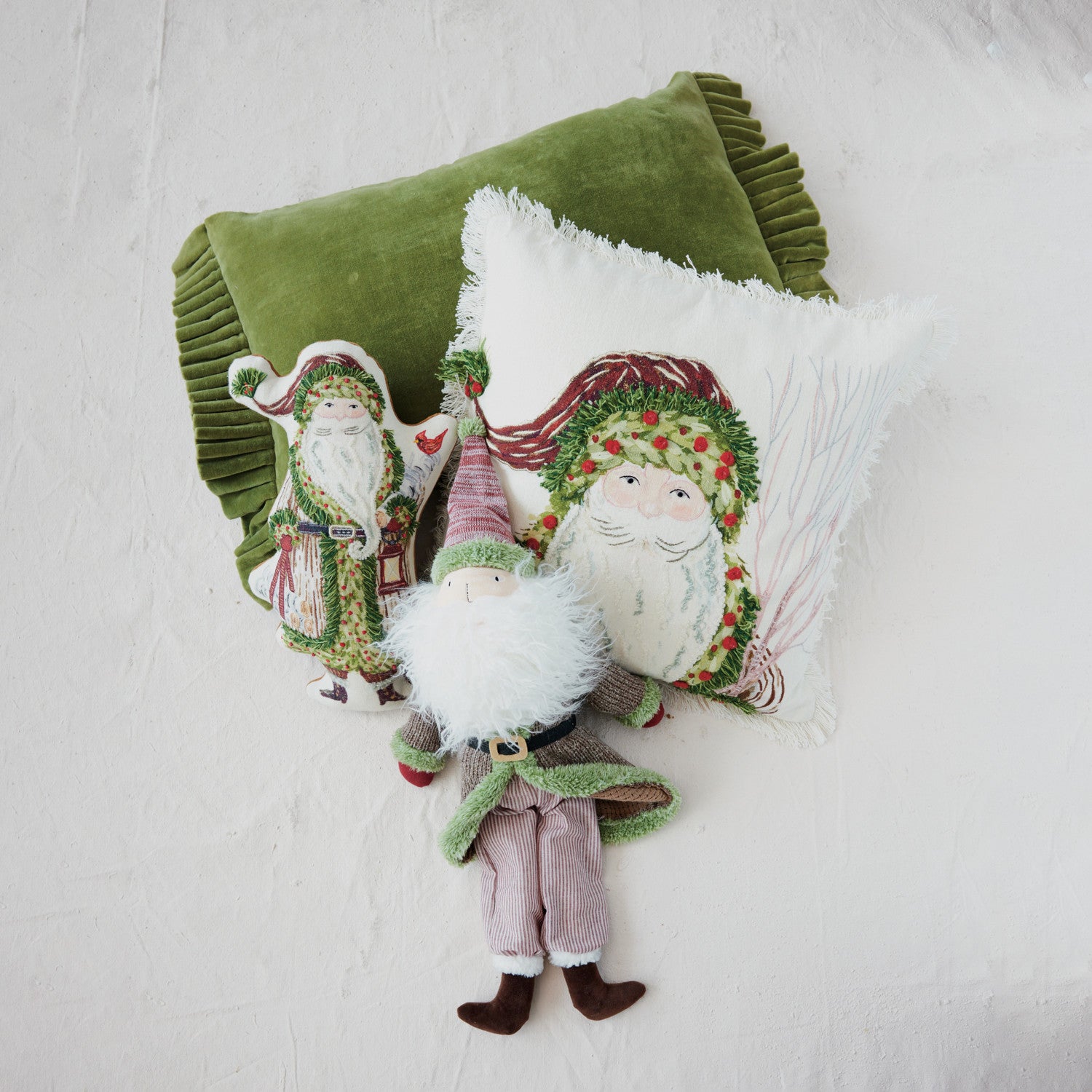 Green cotton velvet lumbar pillow with ruffle trim, styled with festive Santa-themed pillows.