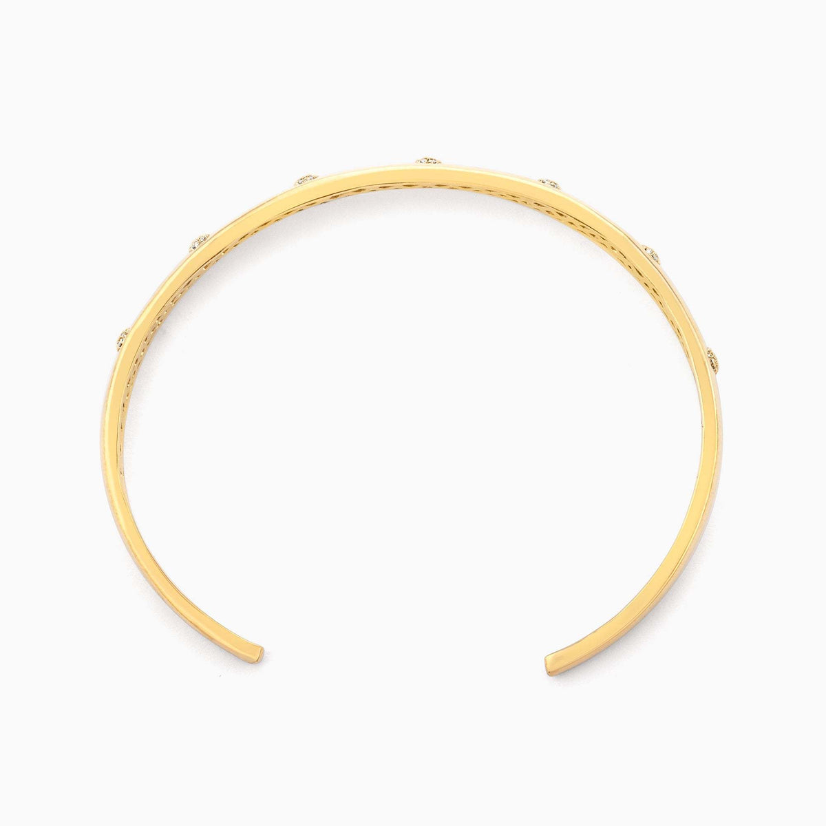 Gold plated stainless steel open cuff bracelet with a subtle lucky number seven detail.