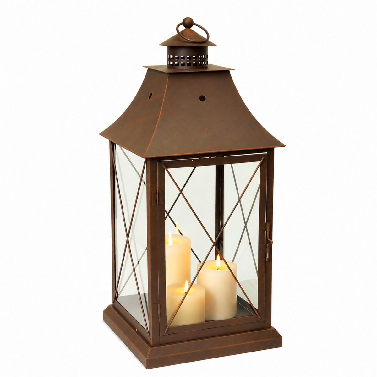 Rustic brown metal lantern with glass panels and three lit pillar candles inside.