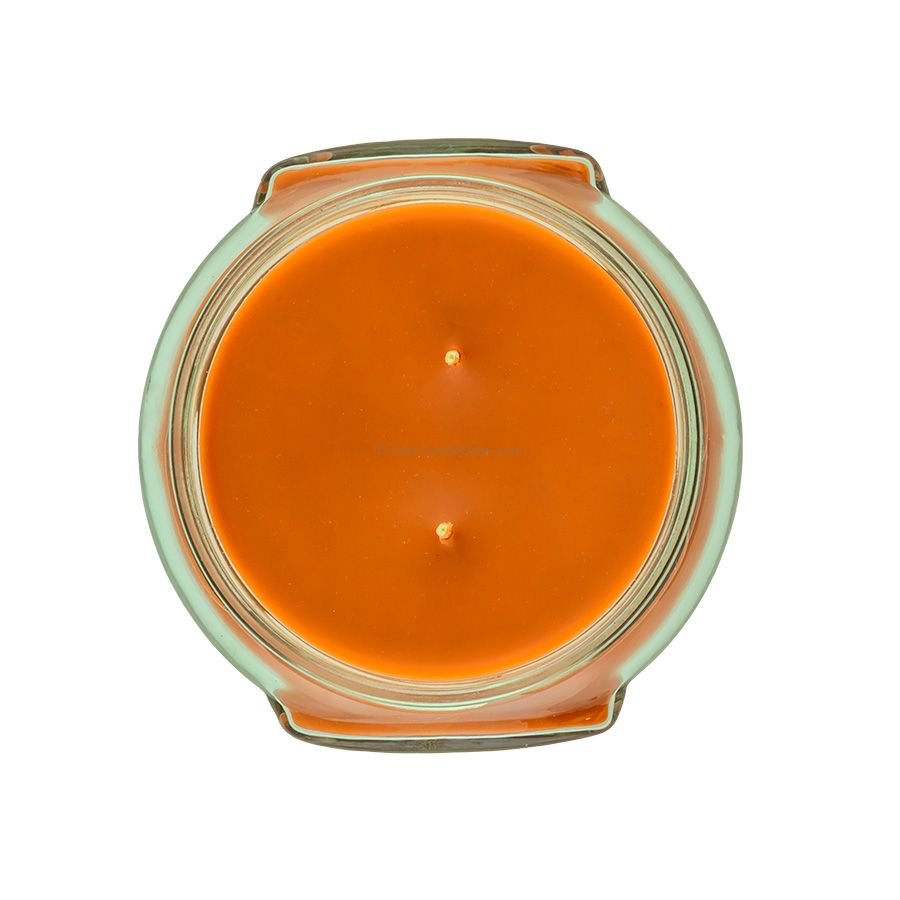 Top-down view of an 11oz Tyler candle in a glass jar with orange wax and two wicks.