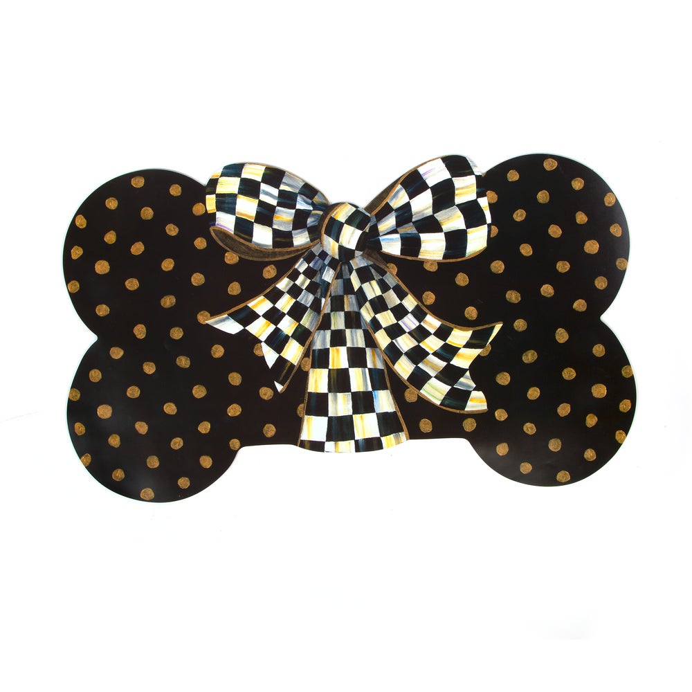 Bone-shaped puppy placemat with black and gold polka dots and a checkered bow in the center.