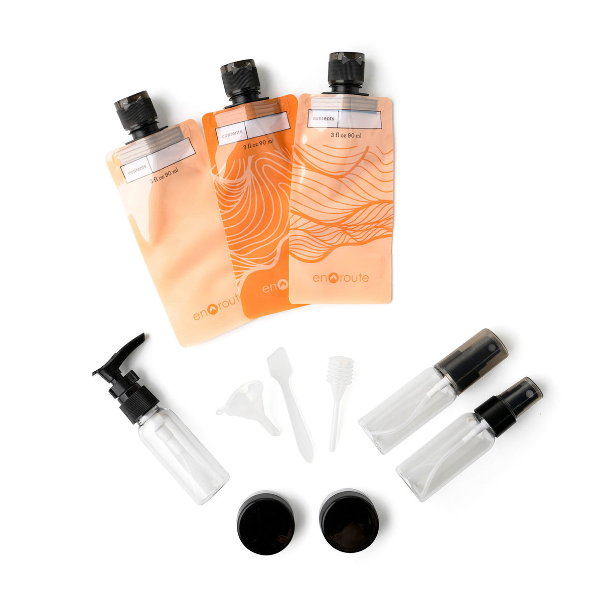 En Route The Jet Set Travel Kit with orange squeeze pouches, spray bottles, pump, jars, and tools.