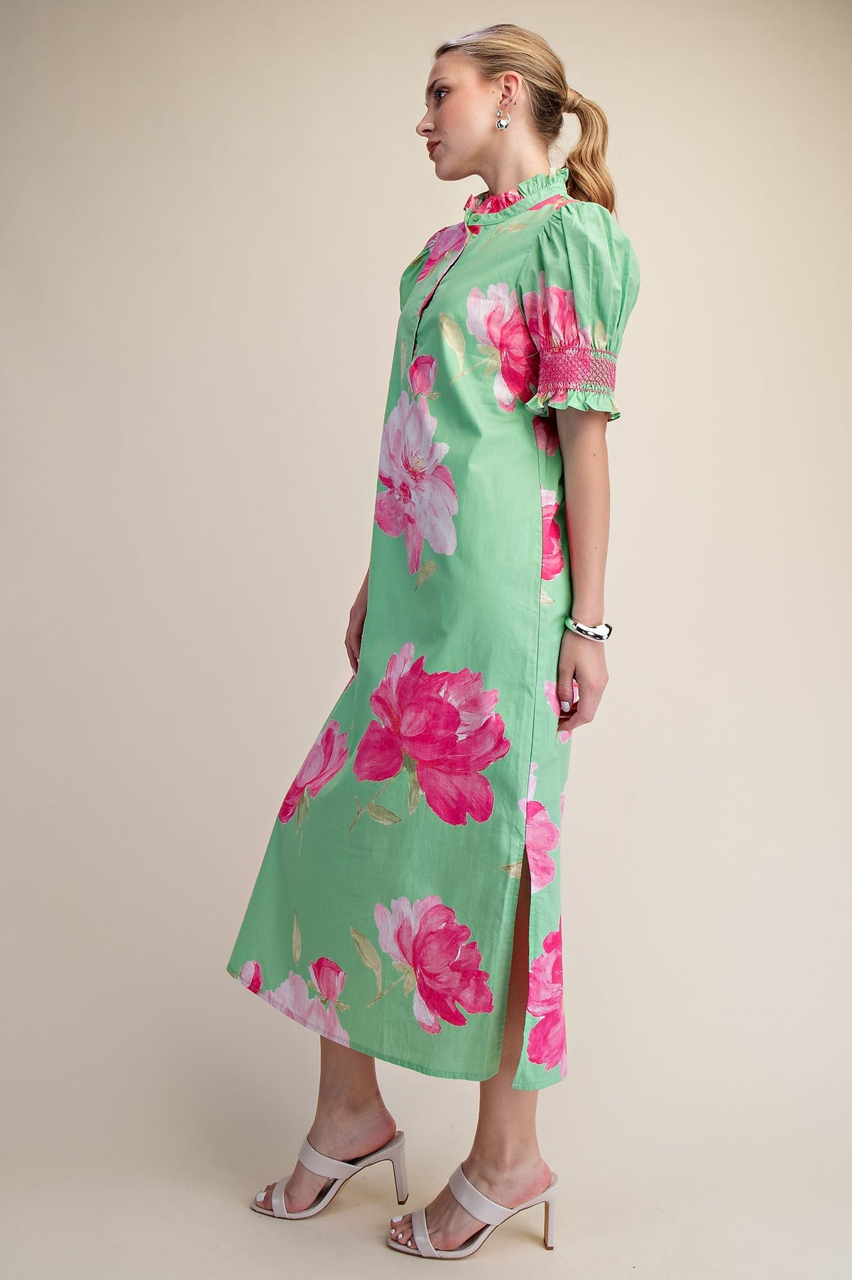 Green midi dress with pink floral print, ruffle neck, puff sleeves, and side slit.