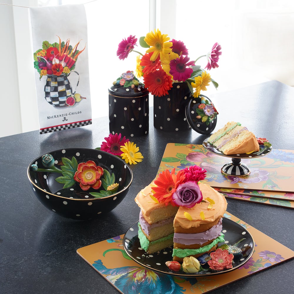 Vegetable Bouquet Dish Towel hanging above a table set with floral cakes and polka dot canisters.