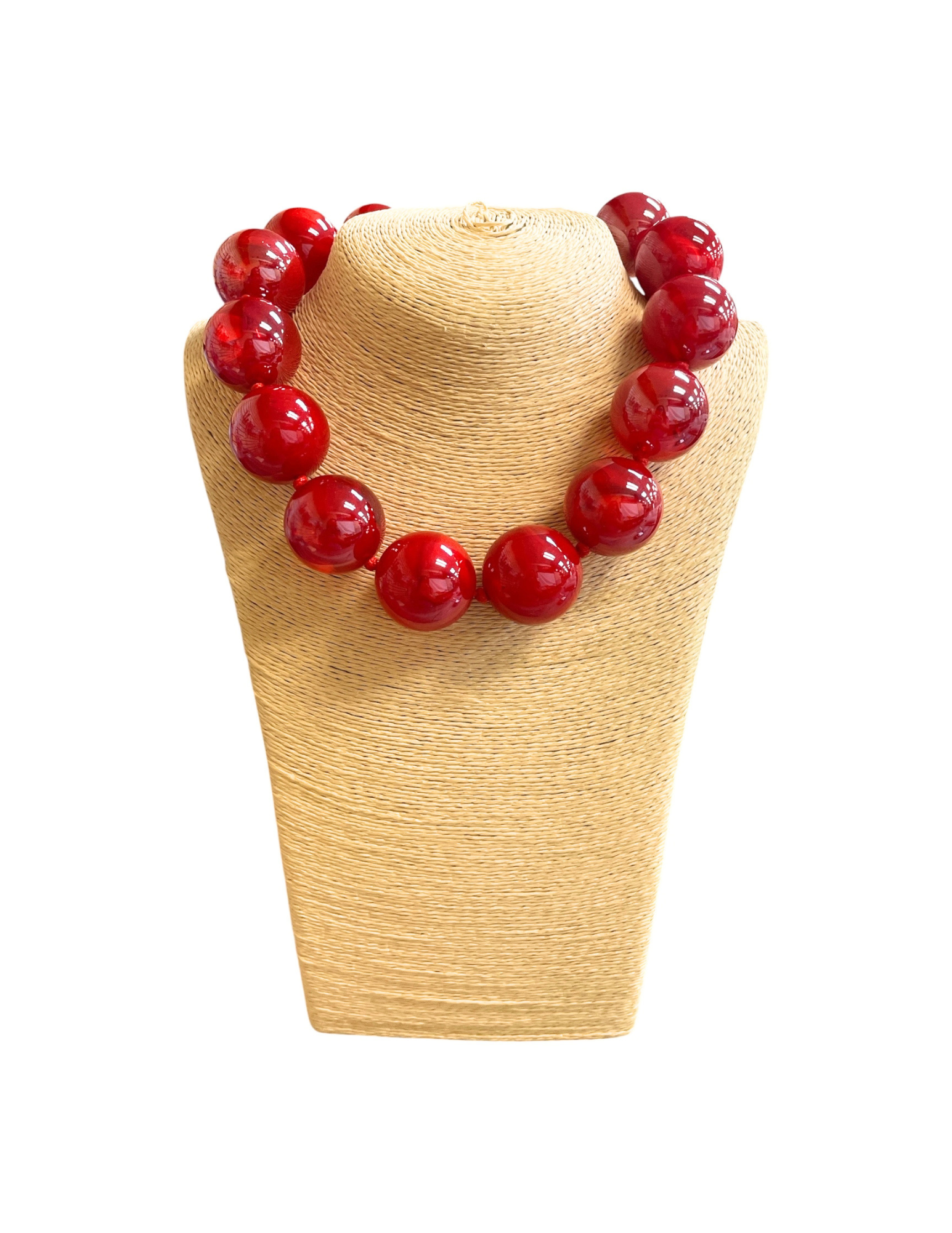 Short necklace featuring large, glossy red glass beads on a woven tan jewelry display bust.
