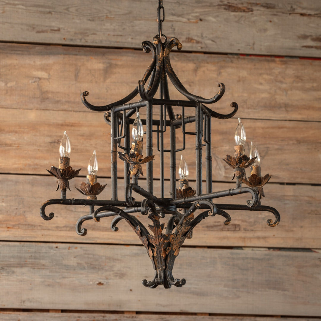 Aged iron pagoda chandelier with a tiered geometric silhouette.