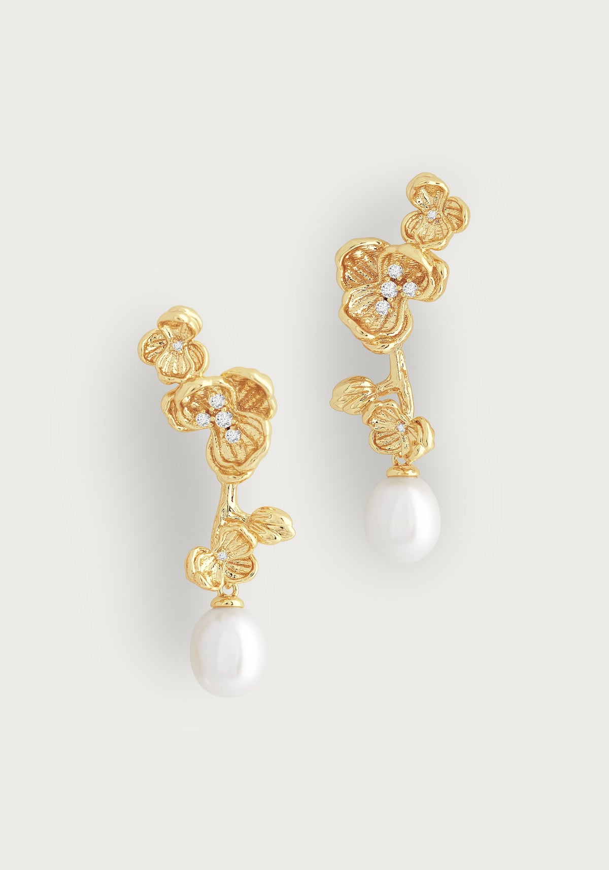 Orchid-shaped 18K gold plated drop earrings with hand-set crystals and white pearl drops.