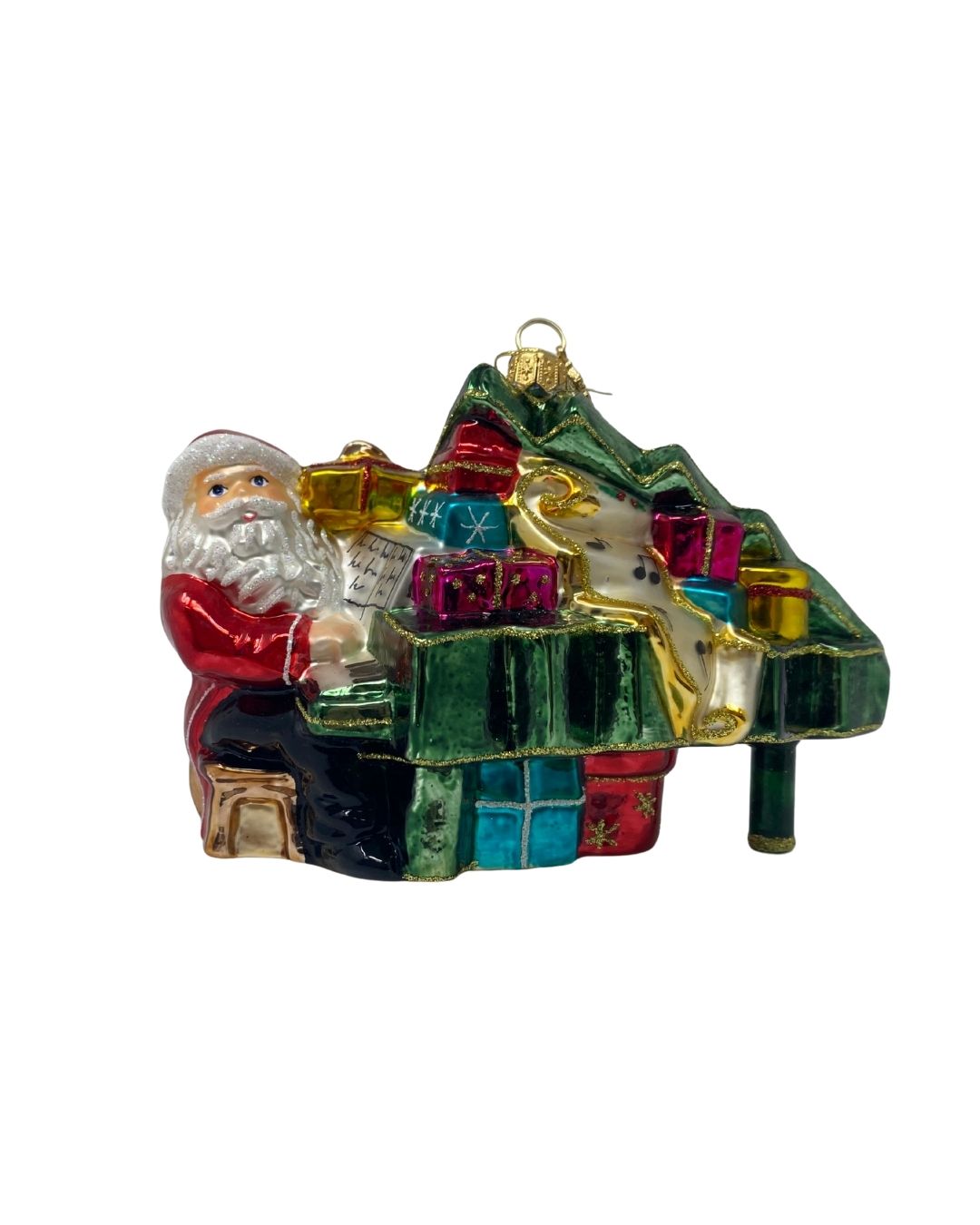 Glass Christmas ornament of Santa Claus playing a green grand piano covered in colorful gifts.