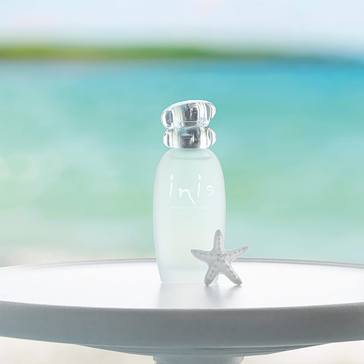 Frosted glass bottle with pebble-style cap containing Inis Cologne Spray