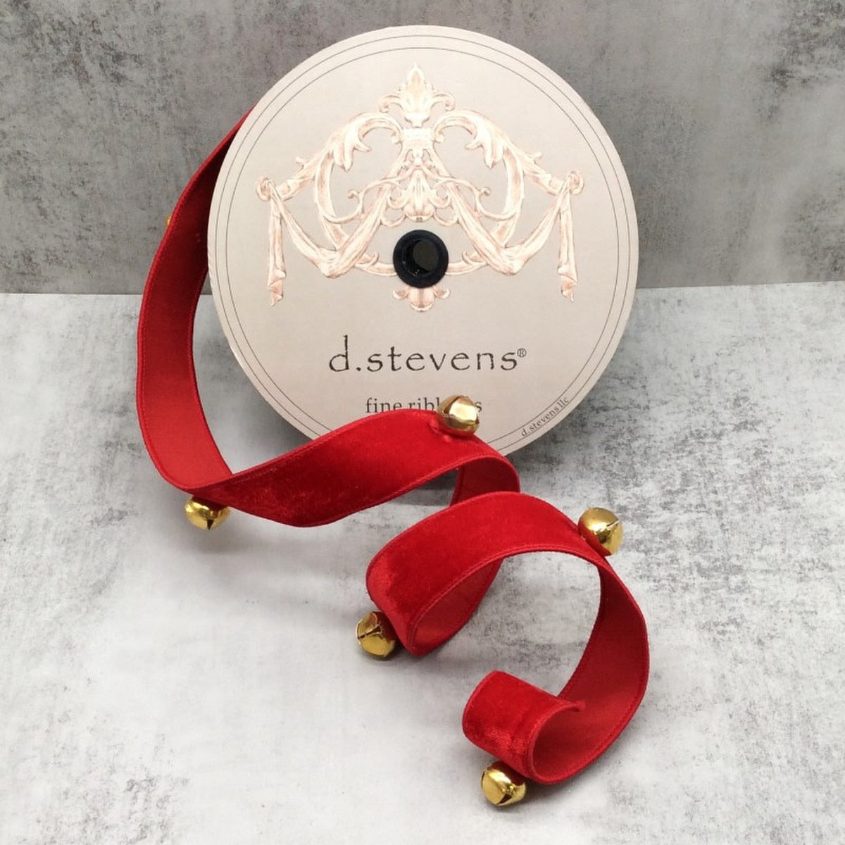 Red velvet fabric swatch with gold jingle bell trim