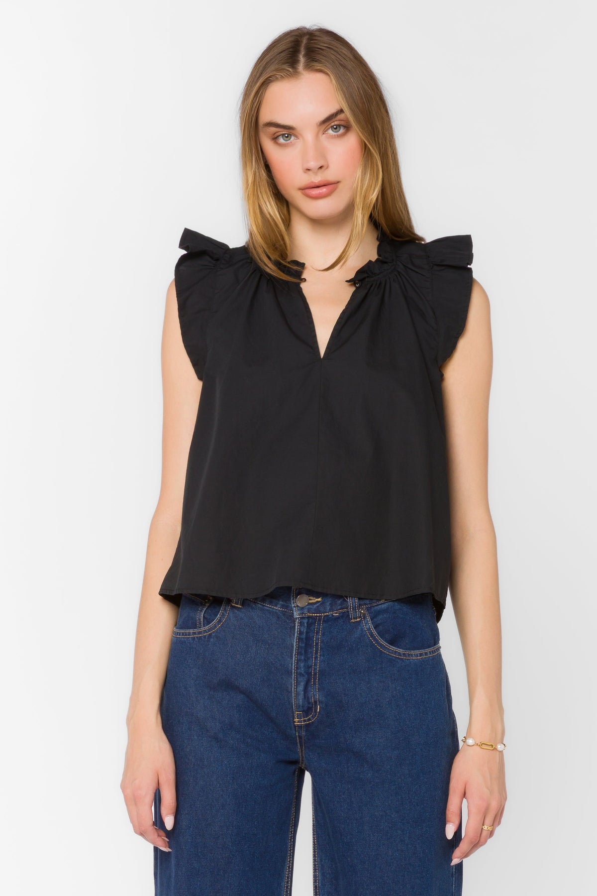 Black cotton poplin sleeveless top with Mandarin collar, V-neckline, ruffle edges, and tie detail.