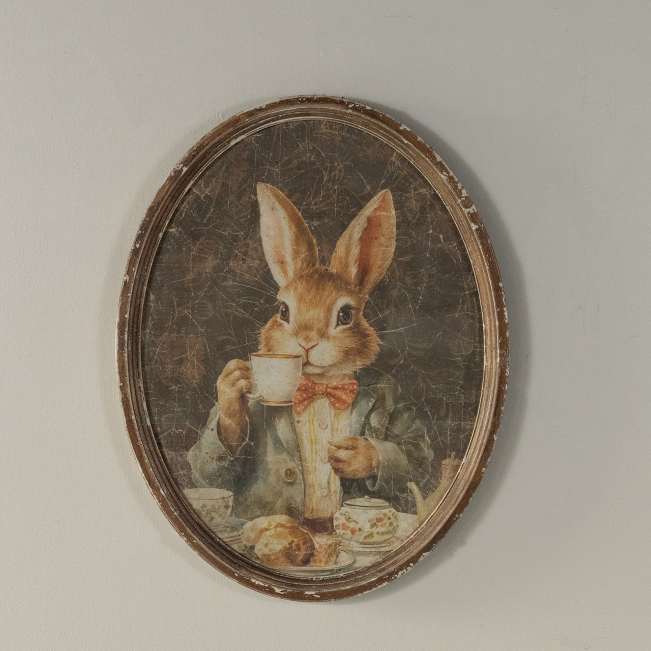Oval framed print on glass showing a bunny sipping tea with wood backing