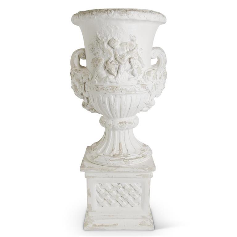 White distressed resin urn with embossed cherub figures on a matching base.