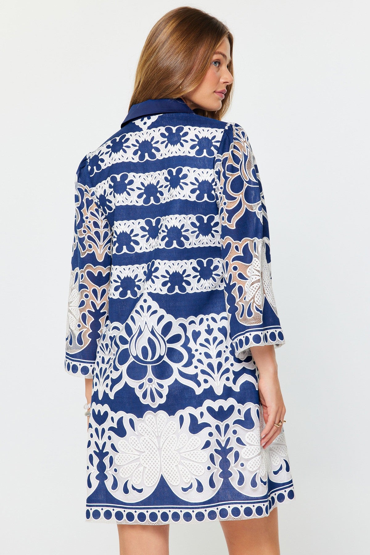 Avery mini dress in rayon/poly blend featuring a collared neckline, button front placket, three-quarter sleeves, and contrast embroidered floral lace.