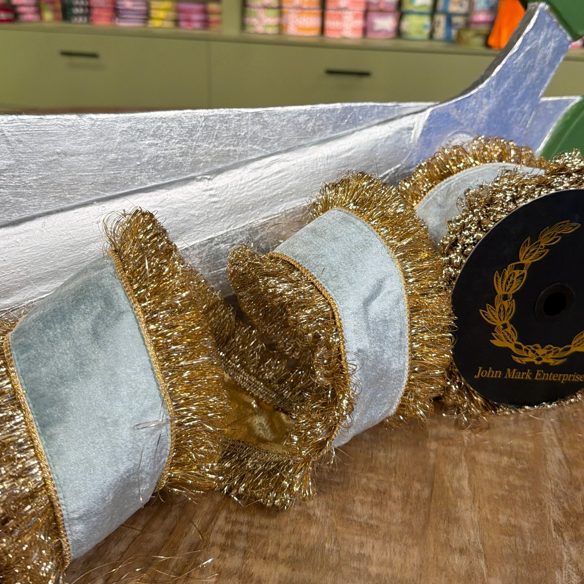 4-inch aqua velvet ribbon with double-sided gold metallic fringe trim and metallic dupion backing.