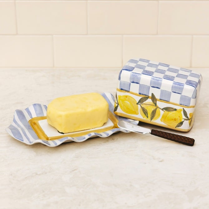 Mackenzie Childs Cheese Gal butter dish featuring a cream-colored ceramic body with blue and white illustrated cheese patterns.