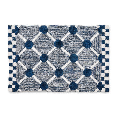 Handmade cotton bath rug with a lattice and dot pattern in neutral tones.