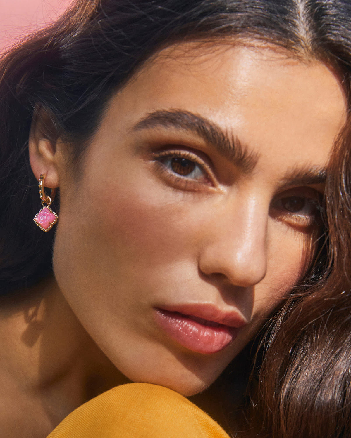 Rose gold huggie earrings with a hinge closure featuring an artistic charm measuring 0.68 inches in diameter.