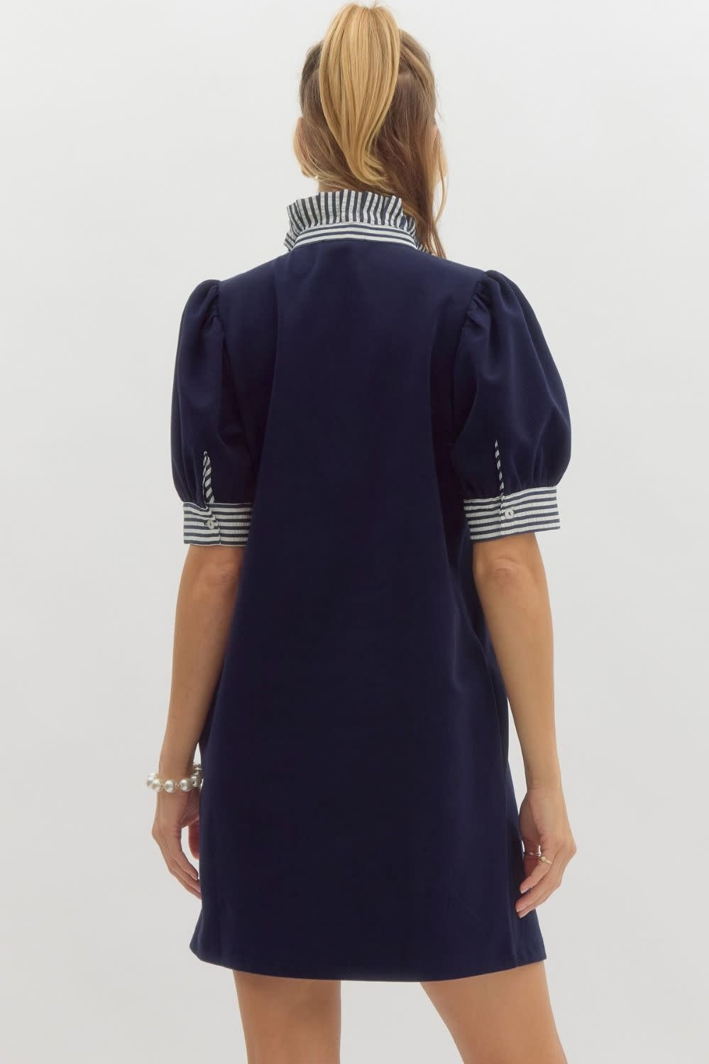Back view of Mandy solid pullover polo dress in light neutral knit with ruffled neck and sleeve bands.