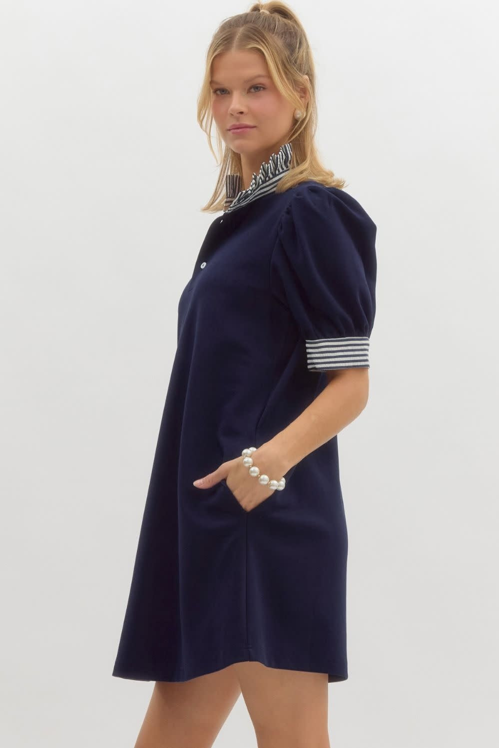 Side view of Mandy solid pullover polo dress in light beige knit with ruffled neck and sleeve bands.