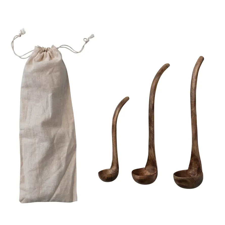 Set of three Scandinavian-inspired mango wood ladles in walnut finish with contemporary silhouettes inside a printed drawstring bag.
