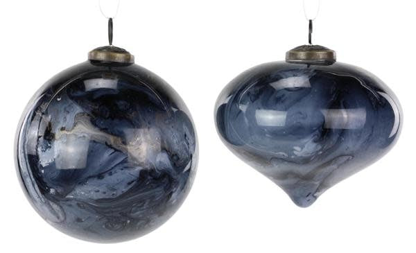 Round glass ornament with white marble swirl pattern on dark background