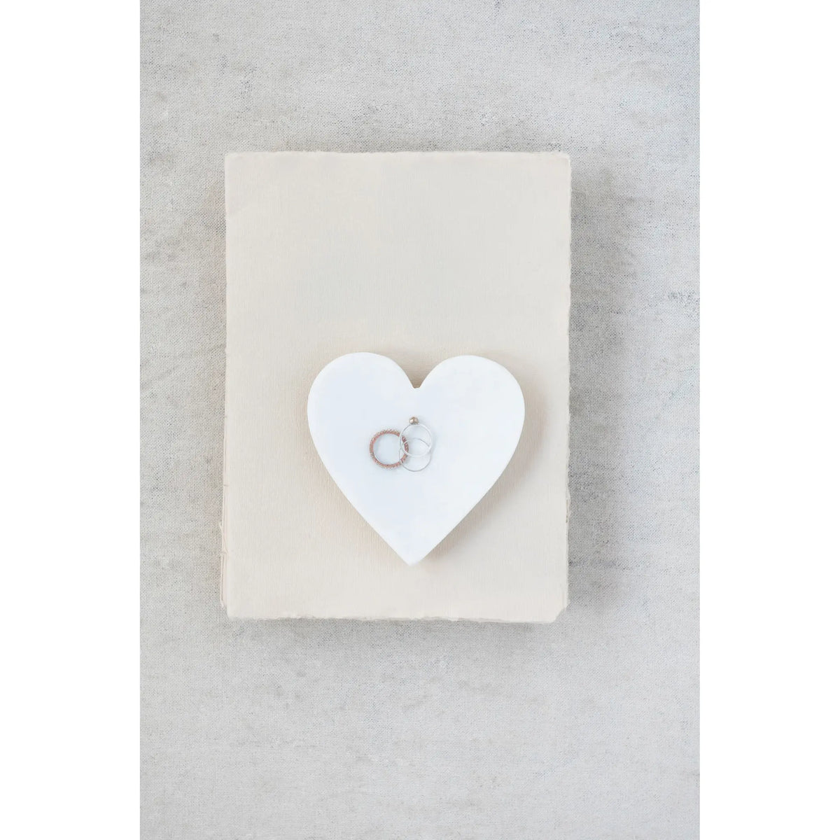 Heart-shaped decorative dish made from white marble with a smooth carved surface.
