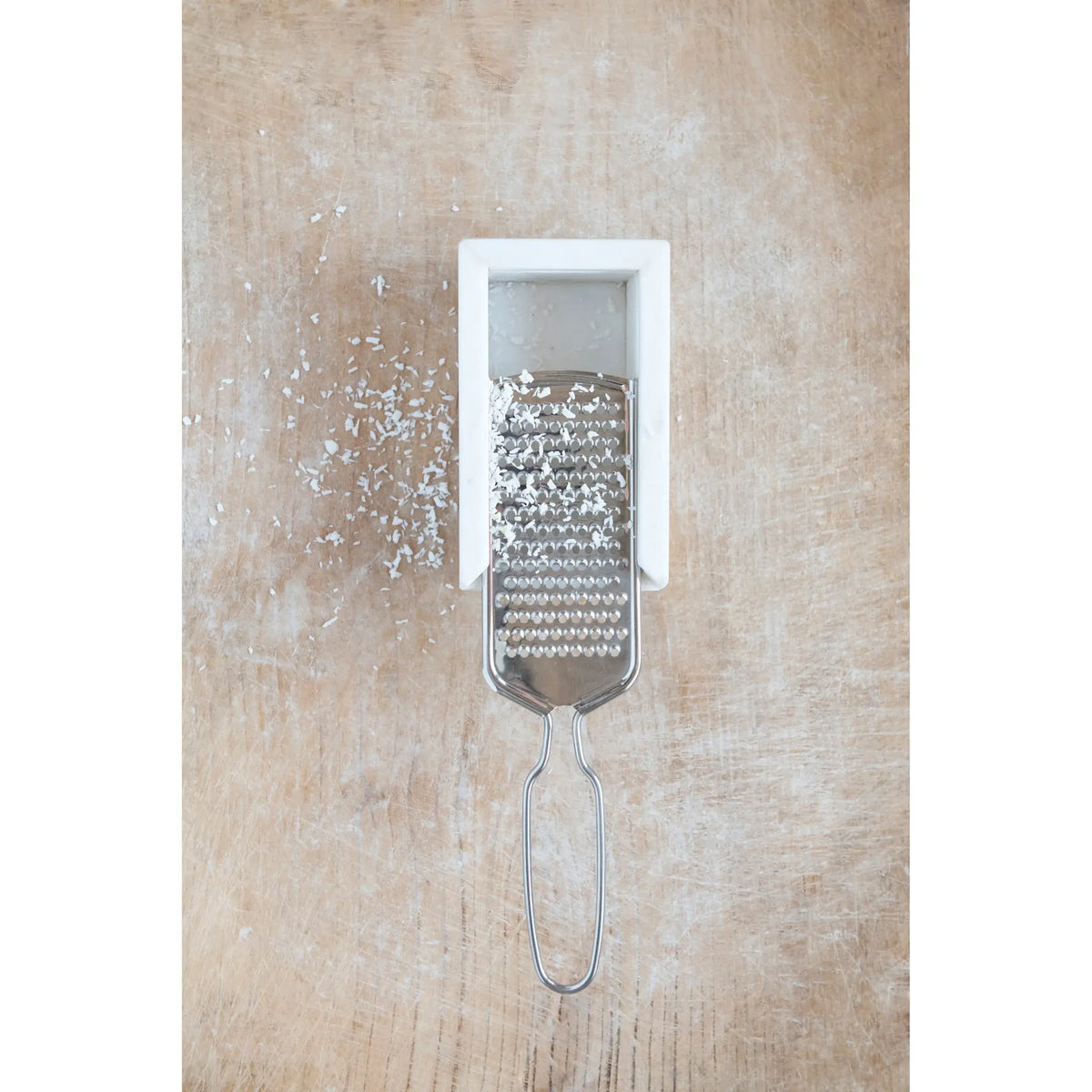 Stainless steel cheese grater with white marble base