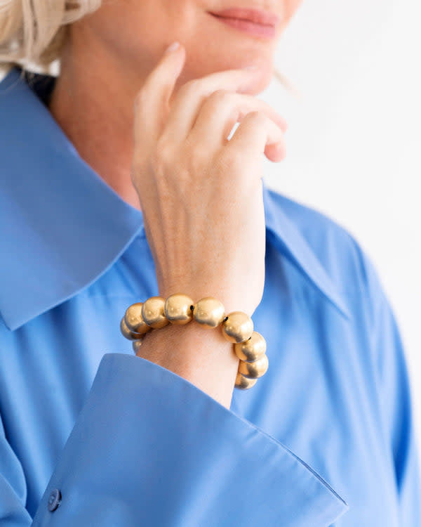 Triple-plated gold stretch bracelet with small bead accents on a simple band.