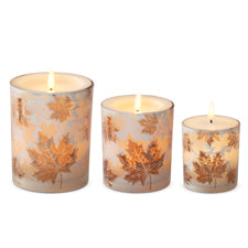 Set of three frosted glass LED candles in varying heights with autumn leaf designs and warm flames.