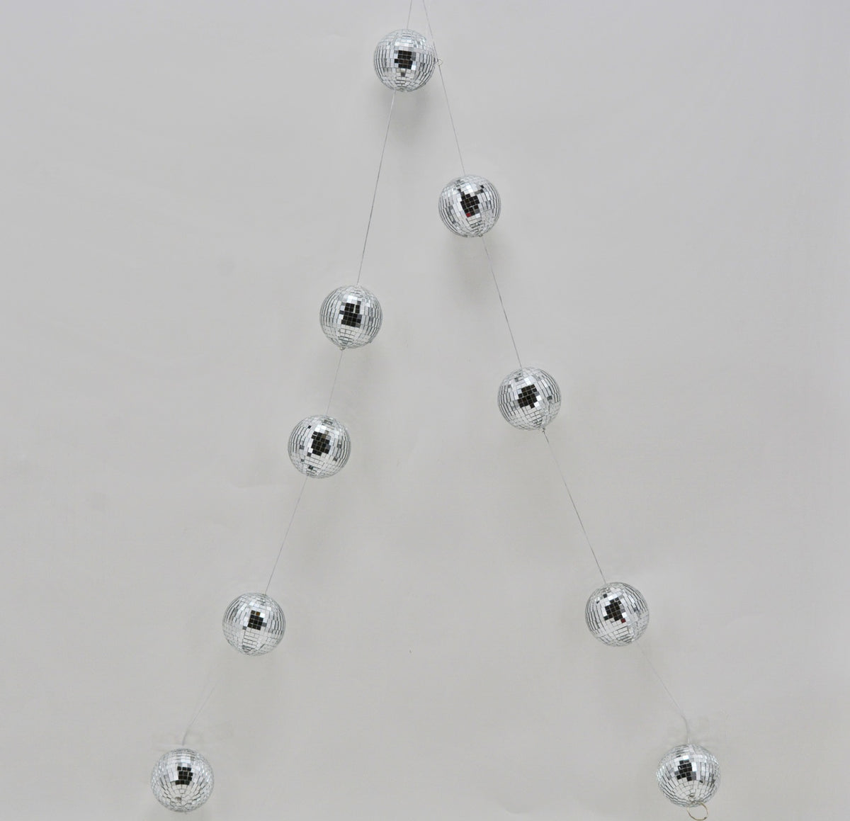 Silver disco ball Christmas garland hanging in a V-shape against a white background.