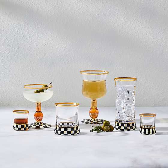 A collection of hand-painted Courtly Check glassware with gold rims and checkered bases.